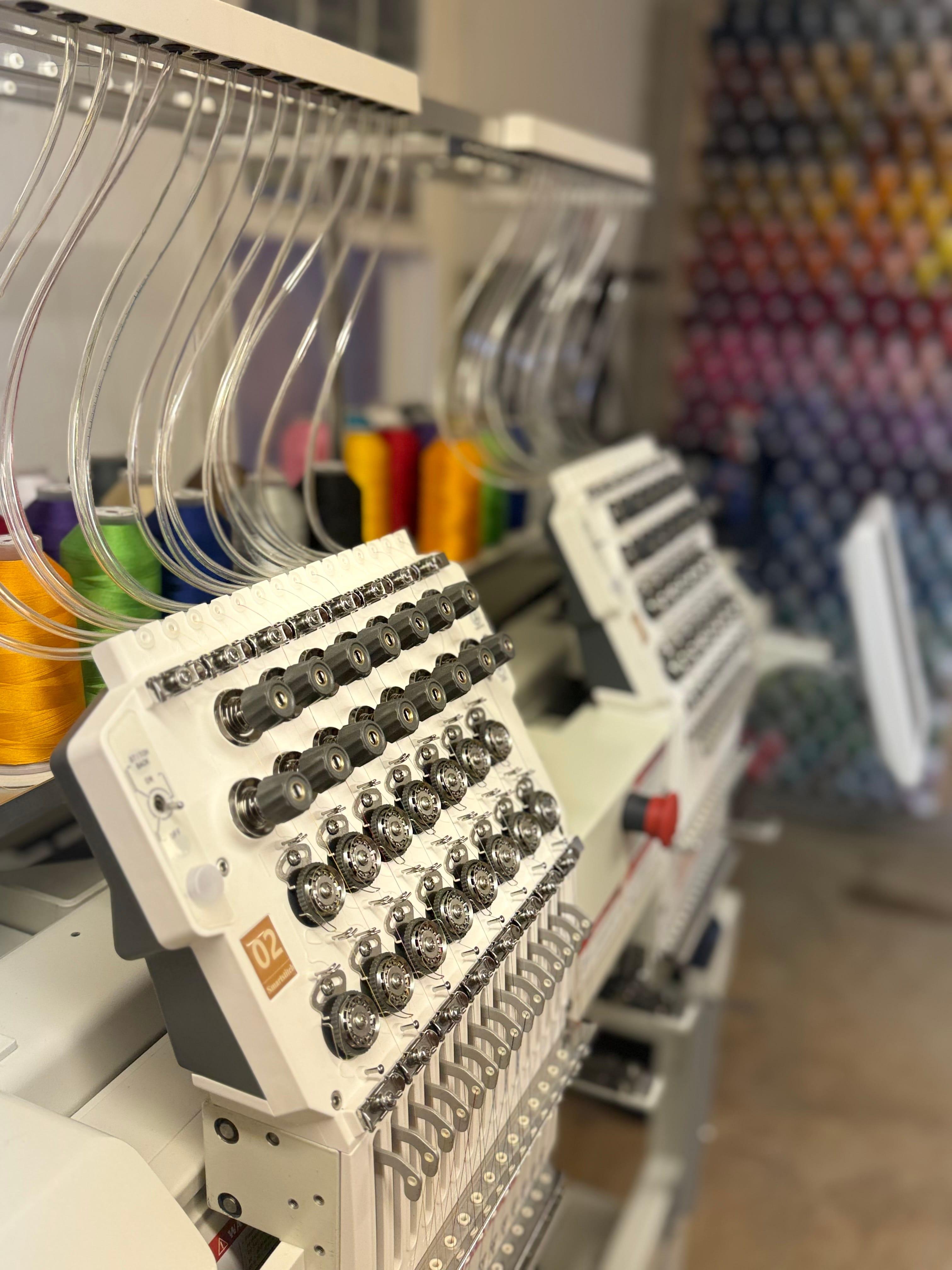 Embroidery machine with multiple spools of colorful thread, showcasing an array of buttons and controls.
